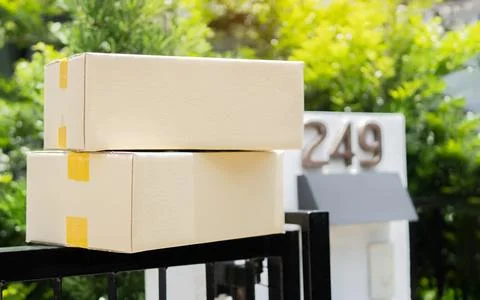 Stack of parcels delivered near front gates, two carton boxes delivered by .. Stock Photos