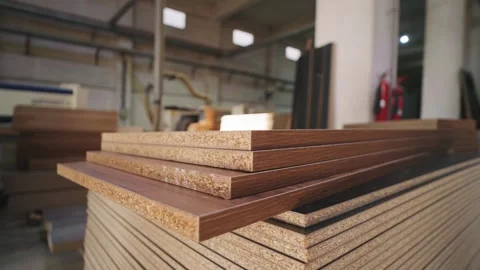 Stack of particle board panels showing wood texture inside furniture factory Stock Footage 307906628