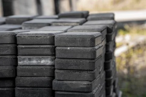 Stack of paving stone on construction site. Bricks for paving stones stacked in Stock Photos