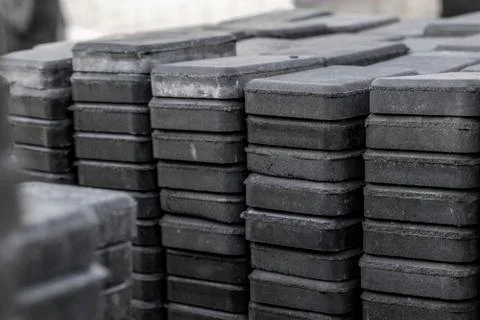 Stack of paving stone on construction site. Bricks for paving stones stacked in Stock Photos