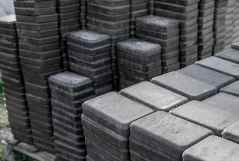 Stack of paving stone on construction site. Bricks for paving stones stacked in Stock Photos