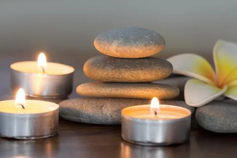 Stack of pebble stones and burning candles Stock Photos