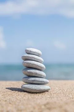 Stack of pebble stones on balance on a sandy beach Stock Photos