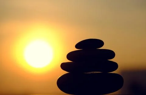 Stack of pebble on yellow sun background Stock Photos