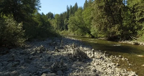 Stack of pebbles on the banks of a river Stock Footage 105410763