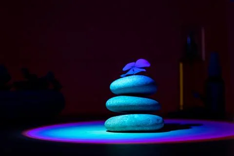 Stack of pebbles with flower, relax calm concept. Ultraviolet background. Stock Photos