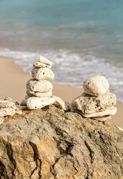 Stack of pebbles by ocean seaside Multiple stacks of pebbles on rock by se... Stockfoto's