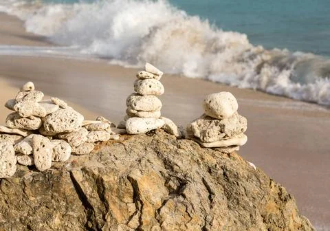 Stack of pebbles by ocean seaside Multiple stacks of pebbles on rock by se... Stockfoto's