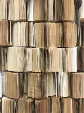 Stack pile of opened old books collection attached to the wall with pages out Stock Photos