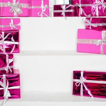 Stack of pink celebration gift boxes with ribbon bows on white table, free sp 스톡 사진