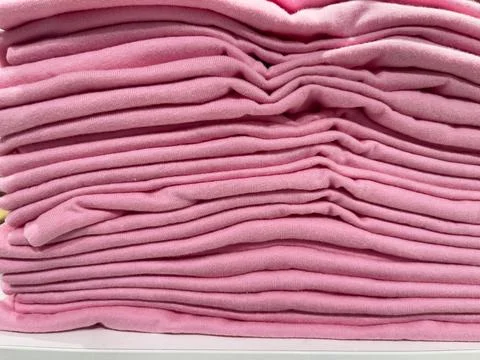 Stack of pink clothes on a white background. Close-up. Stock Photos