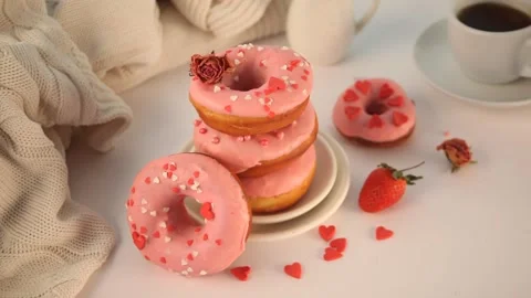 Stack of pink doughnuts on the plate. Valentine's Day concept. Woman hand put a Stock Footage 145122163