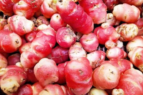 Stack of pink oca on a market stall Stock Photos