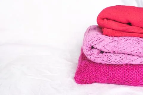 Stack of pink sweaters on white. Stock Photos