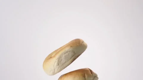 Stack of plain bagels raining on white slow motion macro food studio 4K stock Stock Footage 337909725