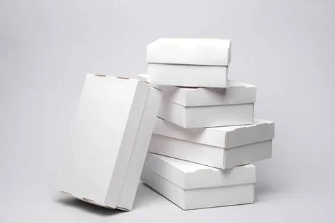 Stack of plain white boxes on gray background Stock Photos