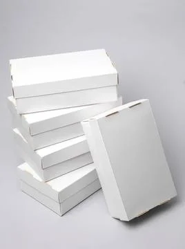 Stack of plain white cardboard boxes on gray background Stock Photos