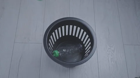 Stack of plastic bottles falls into trash can on parquet Stock Footage 274201831