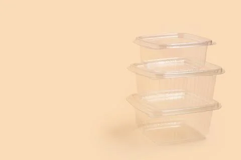 Stack of plastic containers for food on beige background Stock Photos