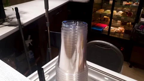A stack of plastic cups. Disposable plastic glasses transparent, cafe drinks. Stock Footage 312638740