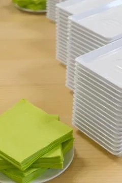 A stack of plastic plates and napkins on a table Foto stock