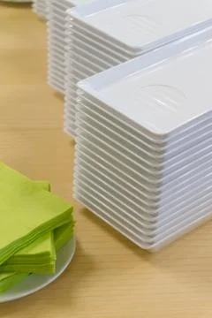 A stack of plastic plates and napkins on a table Stock Photos