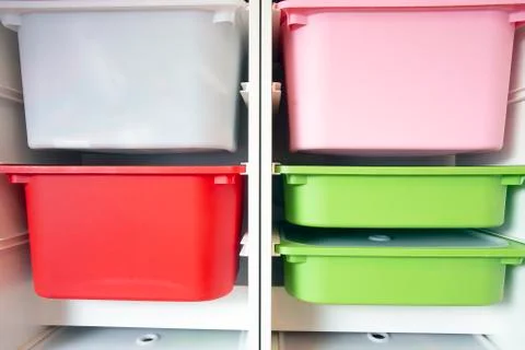 Stack of plastic storage boxes in different colors, sorting system arrangement Stock Photos