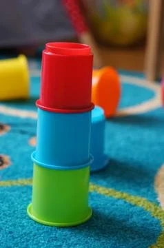 Stack of plastic toy cups on a rug Stock Photos