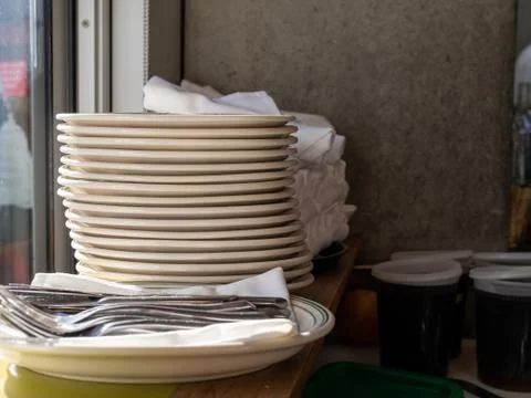 Stack of plates and utensils and containers of sauces Foto stock