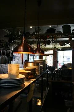Stack up plates in a small dark restaurant kitchen Stock Photos