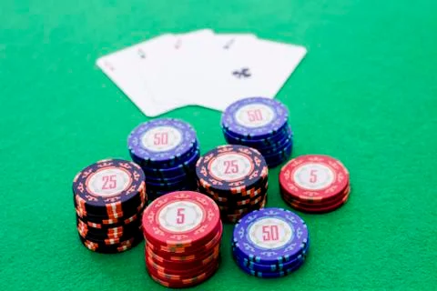 Stack of poker chips and four cards with aces on green background Stock Photos