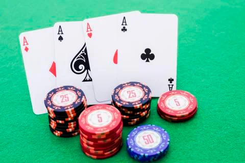 Stack of poker chips and four cards with aces on green background Stock Photos