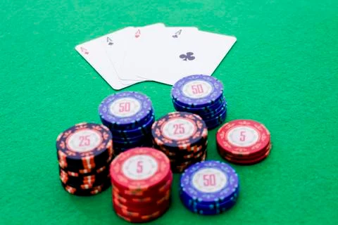 Stack of poker chips and four cards with aces on green background Stock Photos