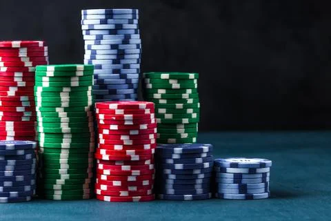 Stack of poker chips on a blue table on a black background Stock Photos