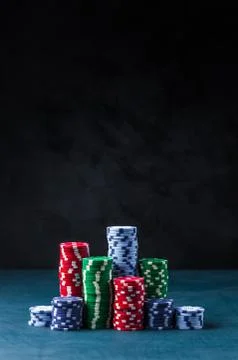 Stack of poker chips on a blue table on a black background Stock Photos