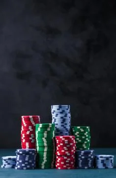 Stack of poker chips on a blue table on a black background Stock Photos