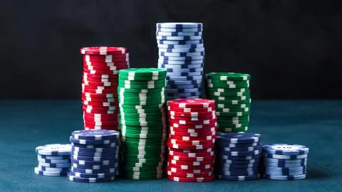 Stack of poker chips on a blue table on a black background Stock Photos