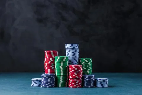Stack of poker chips on a blue table on a black background Stock Photos