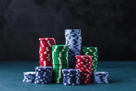 Stack of poker chips on a blue table on a black background Stock Photos