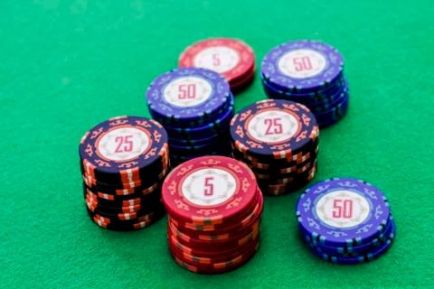 Stack of poker chips on green background Photos