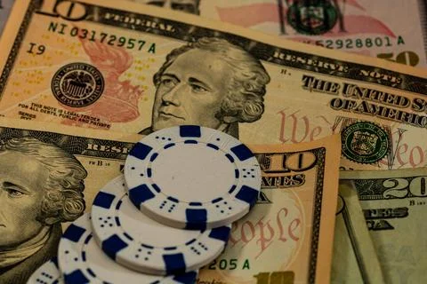 Stack of poker chips over american dollar bills and playing cards represent.. Foto stock