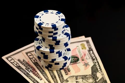 Stack of poker chips over american dollar bills and playing cards represent.. Foto stock