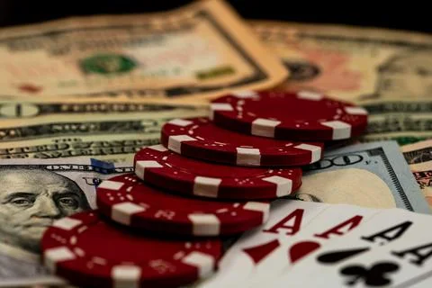 Stack of poker chips over american dollar bills and playing cards represent.. Foto stock