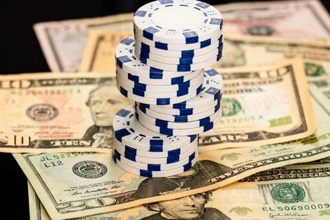 Stack of poker chips over american dollar bills and playing cards represent.. Foto stock