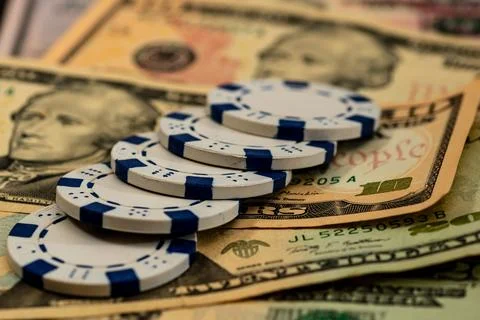 Stack of poker chips over american dollar bills and playing cards represent.. Foto stock