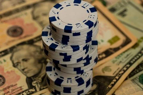 Stack of poker chips over american dollar bills and playing cards represent.. Foto stock