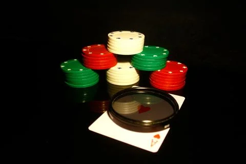 Stack of poker chips with a red hearts card, photo filter  in front and refle Stock Photos