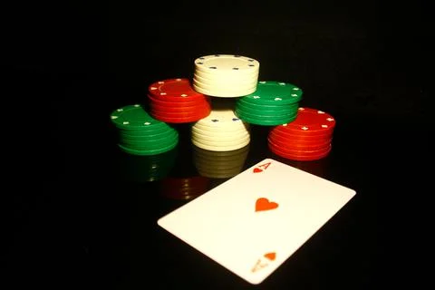 Stack of poker chips with a red hearts card  in front and reflections isolate Stock Photos
