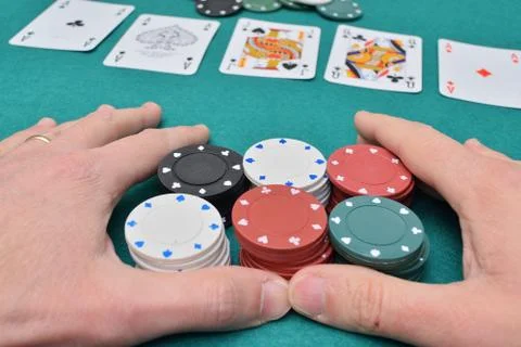 Stack of poker chips in two hands and cards on a gambling table with chips Stockfoto's