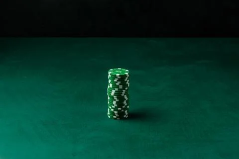 Stack of poker green chips on the table on a black background Stock Photos